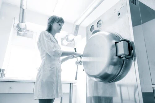 Female scientist working with clean steam autoclave in black and white